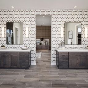 Luxurious primary bathrooms with split vanities, a soaking tub, walk-in shower, and large closets