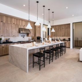 Well-equipped kitchen with beautiful cabinets, quartz countertops, and backsplash