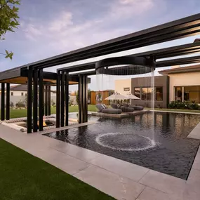 Serene backyard area featuring a large pool, firepit, and water feature