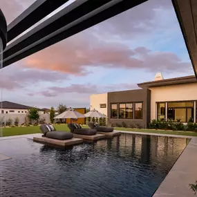 Stunning backyard equipped with pool, expansive back patio for entertaining, and water feature