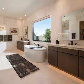 Striking primary bathroom with standalone soaking tub and dual vanities