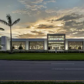 Wide view of Rooms To Go showroom with palm trees at sunset.