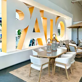 Elegant patio dining setup with natural wood and lantern accents in a modern showroom.