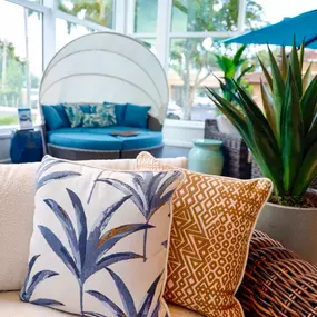 Cozy seating detail with patterned throw pillows and lush greenery.