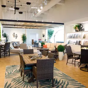 Patio showroom with a variety of outdoor furniture and vibrant green wall decor.