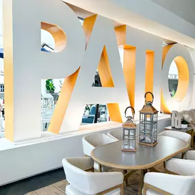 Elegant patio dining setup with natural wood and lantern accents in a modern showroom.