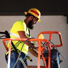 Blue Curb LLC Contractor Operating a Hydraulic Lift to Assist With Washing Windows