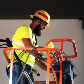 Blue Curb LLC Contractor Operating a Hydraulic Lift to Assist With Washing Windows