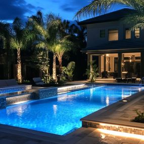 Pool design with spa spillover with lighting at night