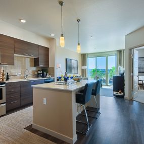 a kitchen with stainless steel appliances and an island with chairs