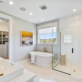 Spa-like primary bathroom with free-standing tub and walk-in shower boasting a frameless glass enclosure