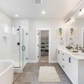 The primary bathroom of the Brookings shown with a free-standing tub and frameless glass shower enclosure