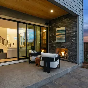 Enjoy seamless indoor-outdoor living through stacking glass doors to a covered patio with a fireplace