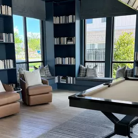 Game lounge with seating, books and a pool table.