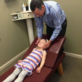 Dr. Pontious performing adjustment on child