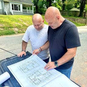 Sterling Park Properties project managers discussing architectural blueprints on site