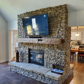 Mantel and stone clad fireplace making a significant design statement in this Sandy Springs home improvement project