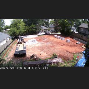 We start to build the retaining wall to prevent soil erosion and to stabilize the dirt on-site. The trailer is delivering the retaining wall build blocks.