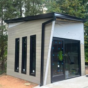 Exterior Construction of custome built ADU or Accessory Dwelling Unit. Durable wood-like and metal siding ensures longevity and a modern aesthetic. Black metal roofing paired with matching gutters offers a sleek, contemporary look.