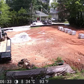 We start to build the retaining wall to prevent soil erosion and to stabilize the dirt on-site. The trailer is delivering the retaining wall build blocks.