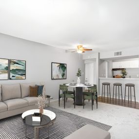 a living room with a couch a table and a chair and a kitchen in the background