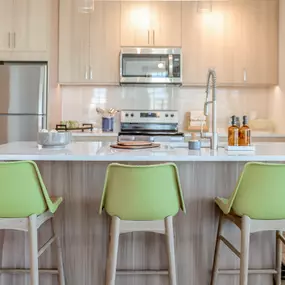 a kitchen with green chairs in front of a counter top