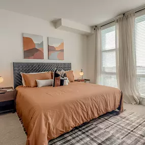 a bedroom with a bed and a chair and a window
