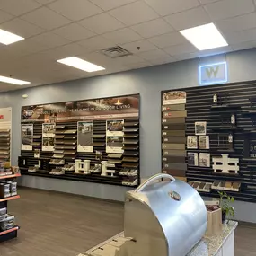 A showroom wall at Builders FirstSource showcasing Trex decking options, railing systems, and other outdoor building materials. The display includes a variety of composite and wood decking samples from top brands, offering solutions for customized outdoor living spaces.