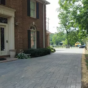 Broken asphalt driveway repaired and expanded with a concrete paver overlay