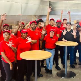 Employees pose for a photograph in the dining room ahead of the grand opening of the Five Guys restaurant at 26401 Novi Road in Novi, Michigan.