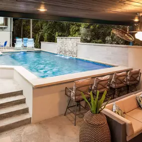 A modern hillside retreat with a pool, custom gazebo, outdoor fireplace and poolside bar