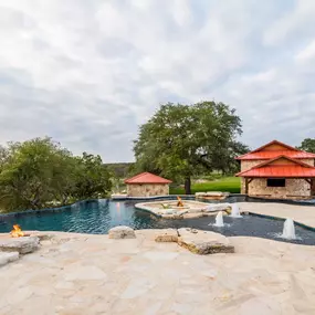 A ranch retreat with an infinity edge pool raised spa, swim-up bar, fire pit and two waterfalls