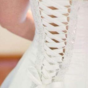 Expertly crafted corset back on a stunning wedding dress. Let us enhance your dream gown with impeccable alterations.