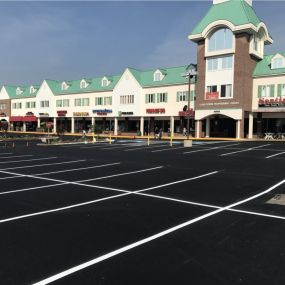 Freshly paved parking lot outside of a strip mall.