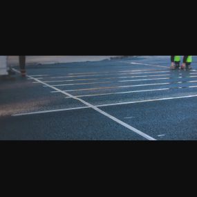 Chamberlain Contractors employee measuring the out the parking lines