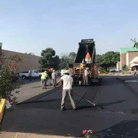 Chamberlain Contractors employees raking newly laid asphalt at a job site