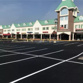 Freshly paved parking lot outside of a strip mall.