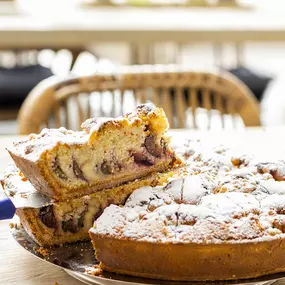 Blumen-Risse, Gartencafé, Café, Dortmund-Soelde, frischen-leckeren-Pflaumenkuchen-anschneiden, Pausenzeit, Kuchenzeit