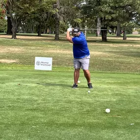 Golfer teeing off at the Home Instead sponsored hole #8 at the Quincy Area Chamber of Commerce Golf Tournament