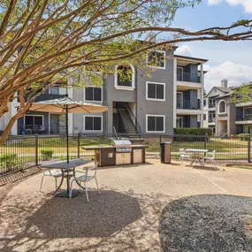 A courtyard with a picnic table surrounded by trees and apartment buildings
