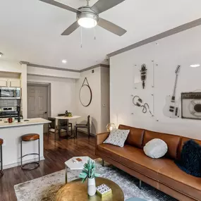 A living room with a brown leather couch and a coffee table in front of it