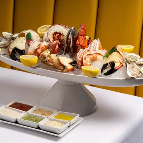 Enjoy our locally and ethically sourced raw bar, including this seafood platter and assorted sauces.