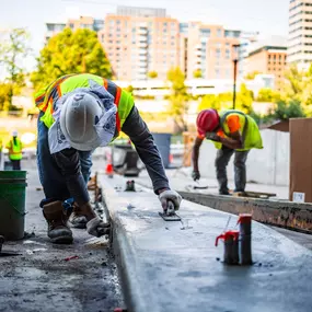 Pro-Pave Inc. Contractor Smoothing Concrete With a Float