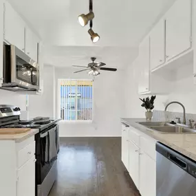 a kitchen with white cabinets and stainless steel appliances