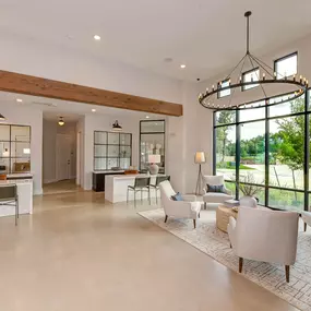 the living room has large windows and a chandelier