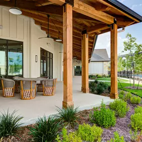 a covered patio with a table and chairs