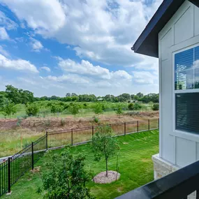 the view of the yard from the balcony of a home