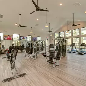 a gym with cardio machines and glass windows