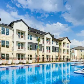 a large swimming pool in front of an apartment building