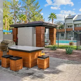 A modern barbecue station at Sono Tempe Apartments situated beside the sparkling swimming pool.